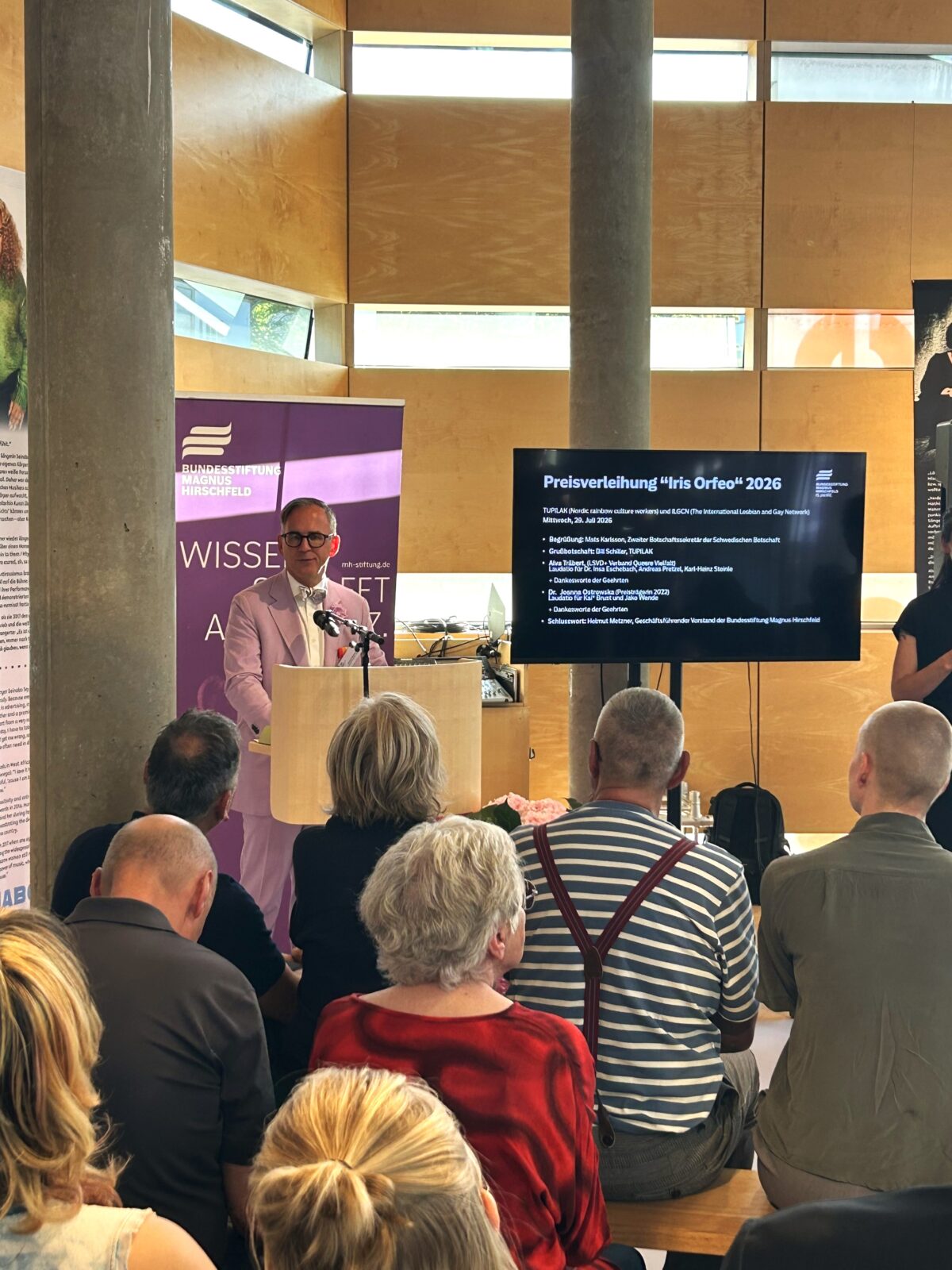 Foto. Zu sehen ist BMH-Vorstand Helmut Metzner auf dem Podium der feierlichen Zeremonie in der Schwedischen Botschaft. Im Vordergrund sitzendes Publikum.