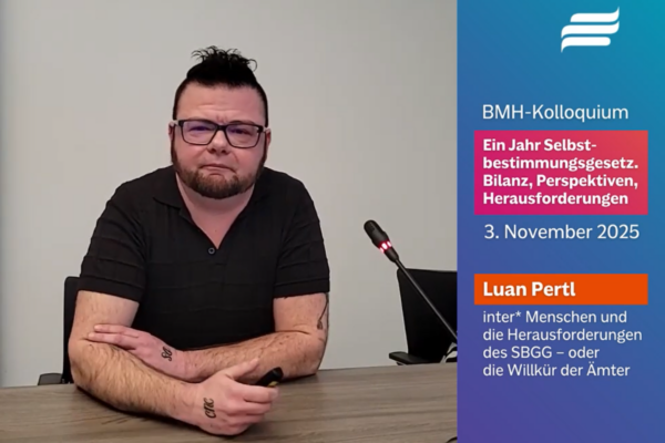 Screenshot des Videos “Vortrag: Inter* Menschen und die Herausforderungen des SBGG – oder die Willkür der Ämter”. Zu sehen ist Luan Pertl neben einem Mikrofon.